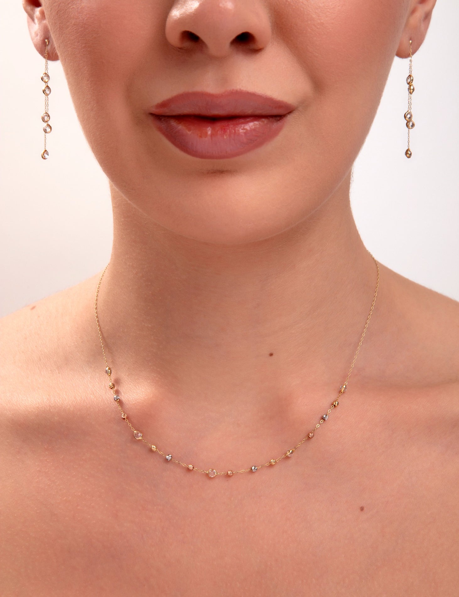 Tricolor mirror bead necklace and earrings on model, mixed metal reflective beads in gold, silver, and rose tones

