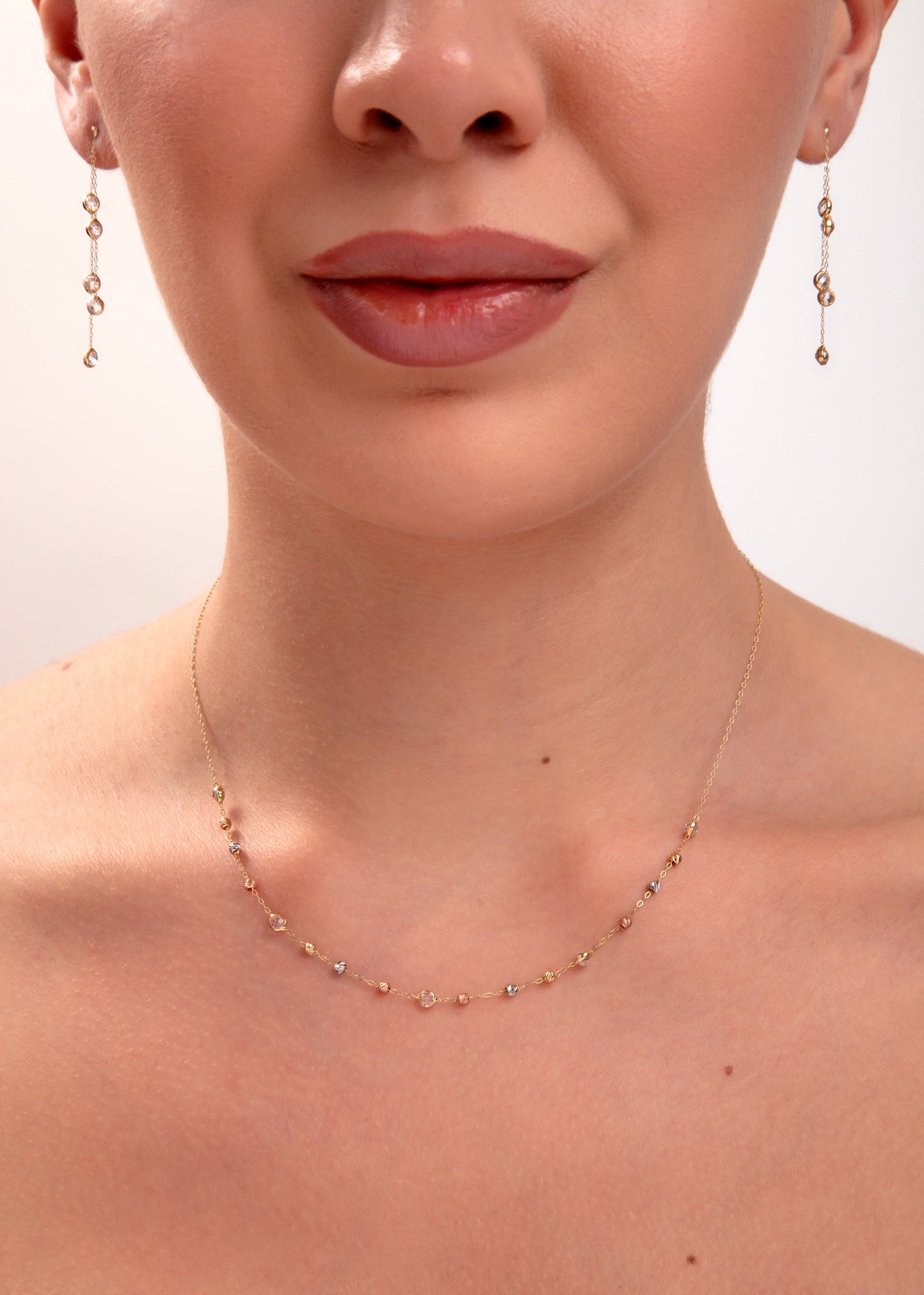 Tricolor mirror bead necklace and earrings on model, mixed metal reflective beads in gold, silver, and rose tones

