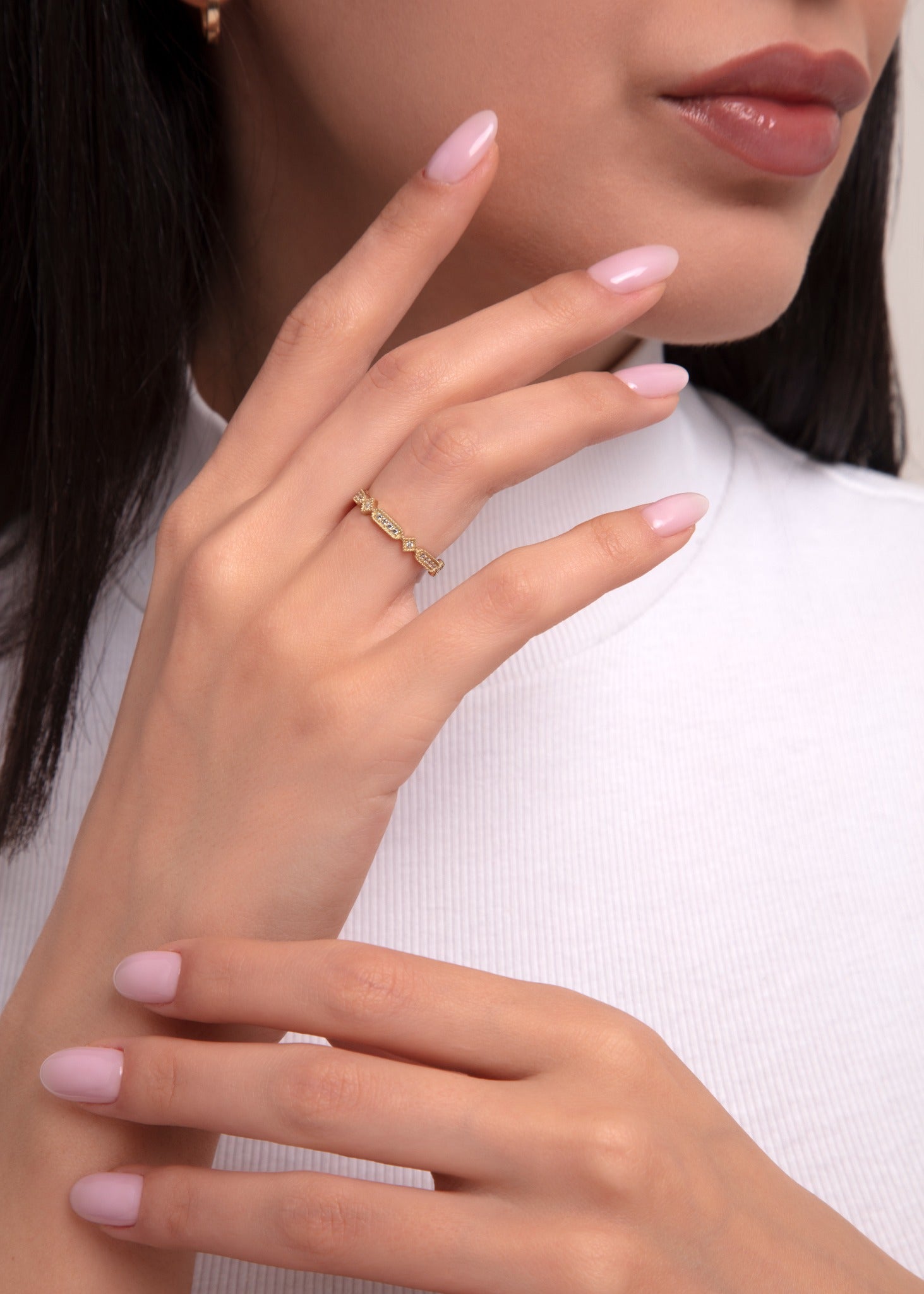Geometric baguette-cut gold ring with vintage design, worn on female hand