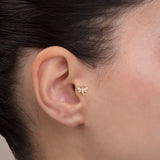 ear model wearing butterfly gold tragus earring suitable for helix cartilage