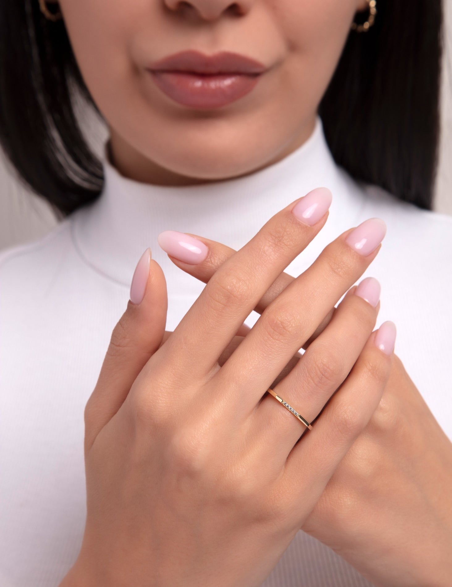 close-up of a woman wearing a minimalist 14k gold ring with tiny diamonds

