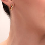 close-up of geometric gold huggie hoop earring