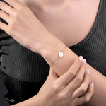 14K gold bracelet with a personalized round disc charm on a double chain, presented on a purple satin background