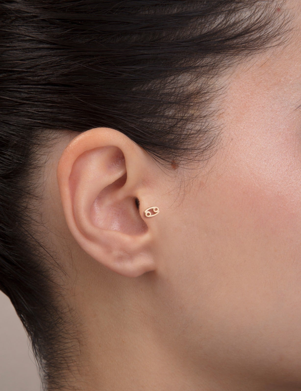 ear model wearing cancer zodiac gold tragus stud horoscope jewelry