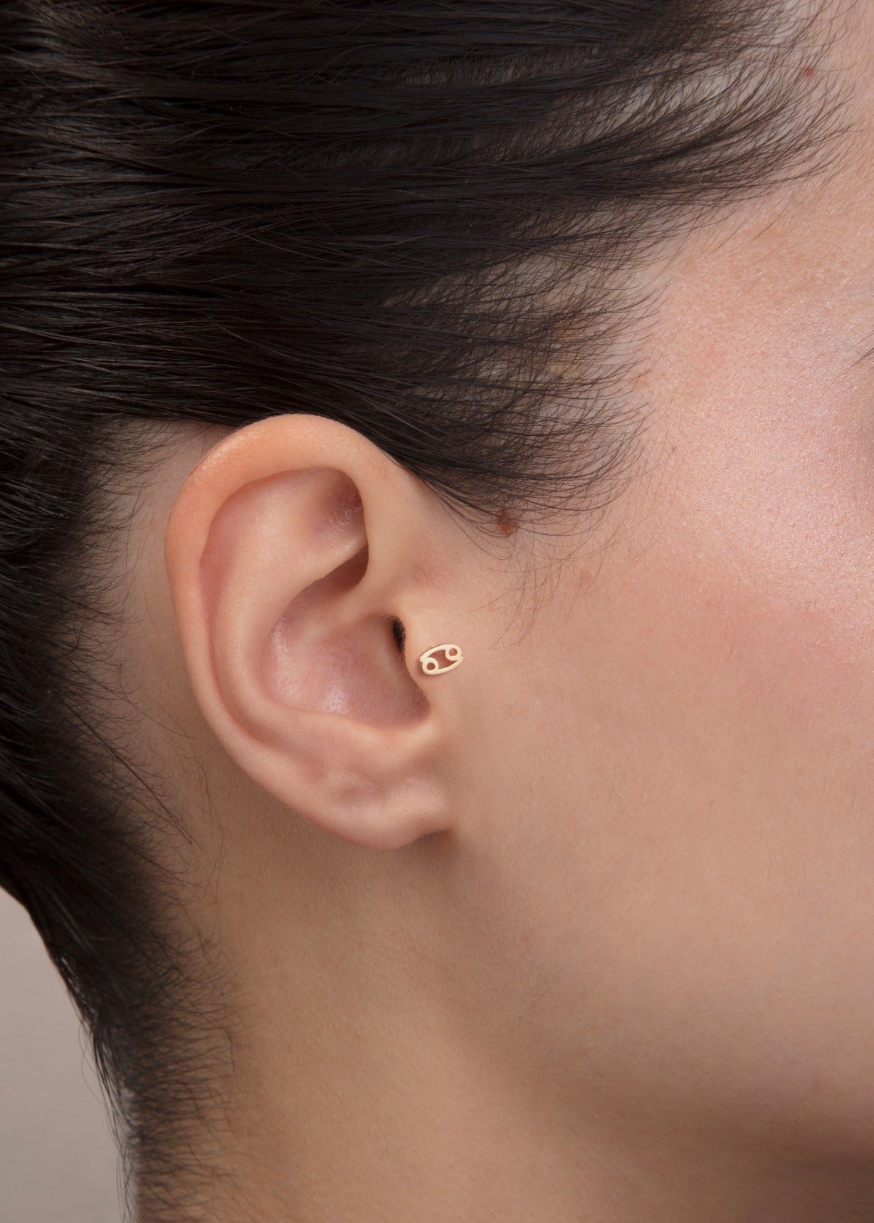 ear model wearing cancer zodiac gold tragus stud horoscope jewelry