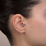 ear model wearing evil eye gold tragus earring suitable for helix cartilage