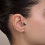ear model wearing marquise blue stone gold tragus earring suitable for helix cartilage