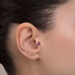 ear model wearing pink cluster gold tragus earring for helix cartilage