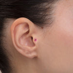 ear model wearing pink stone gold tragus earring suitable for helix cartilage