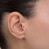 ear model wearing pink stone gold tragus earring suitable for helix cartilage