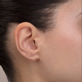 ear model wearing virgo zodiac gold tragus earring for helix cartilage
