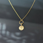 14K gold necklace with engraved initial M on round disc charm and twisted loop detail