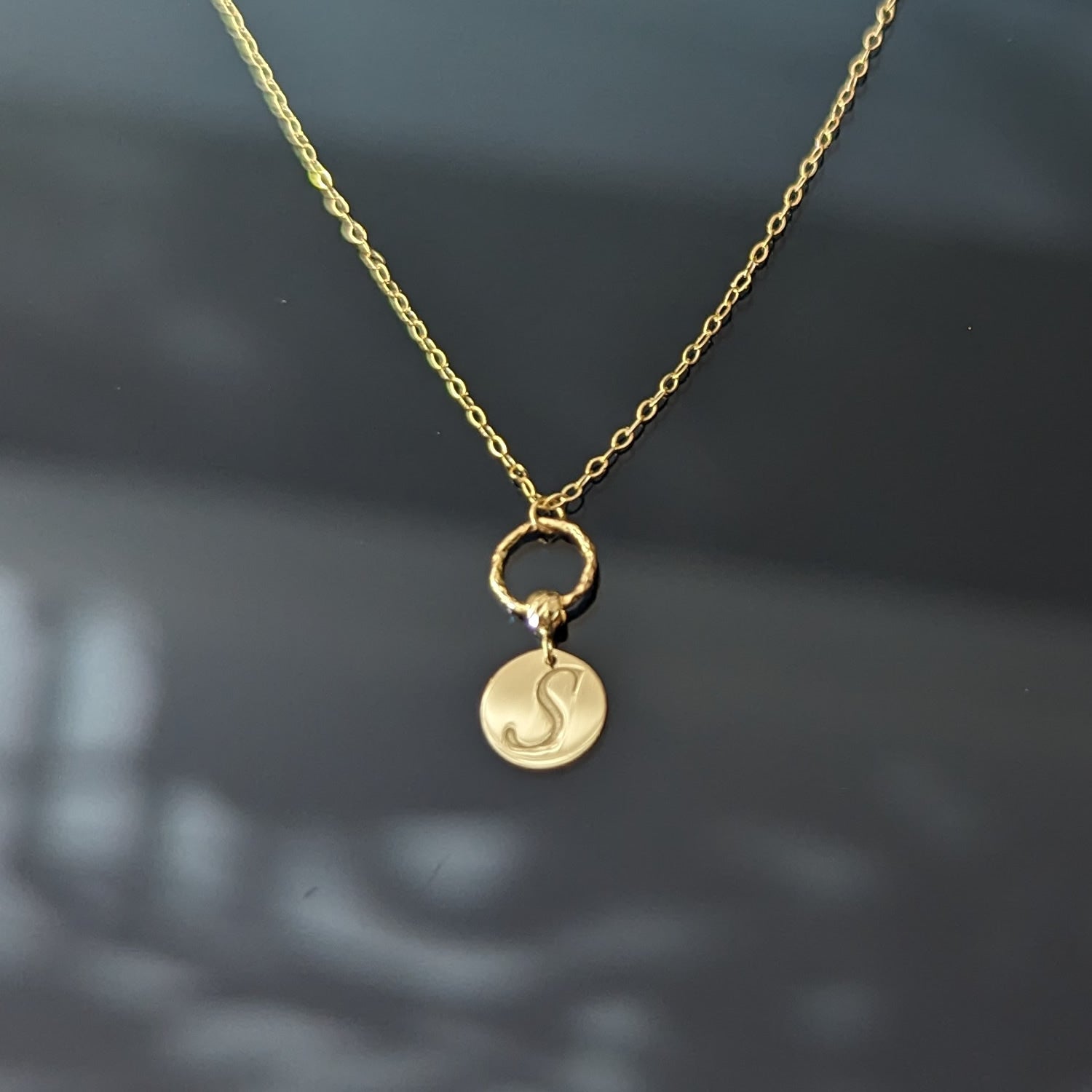 14K gold necklace with engraved initial M on round disc charm and twisted loop detail