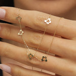 Minimalist 14K gold necklace with three evenly spaced clover charms,