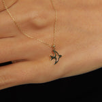 14K gold necklace with a flying bird pendant, graceful, and symbolic design.