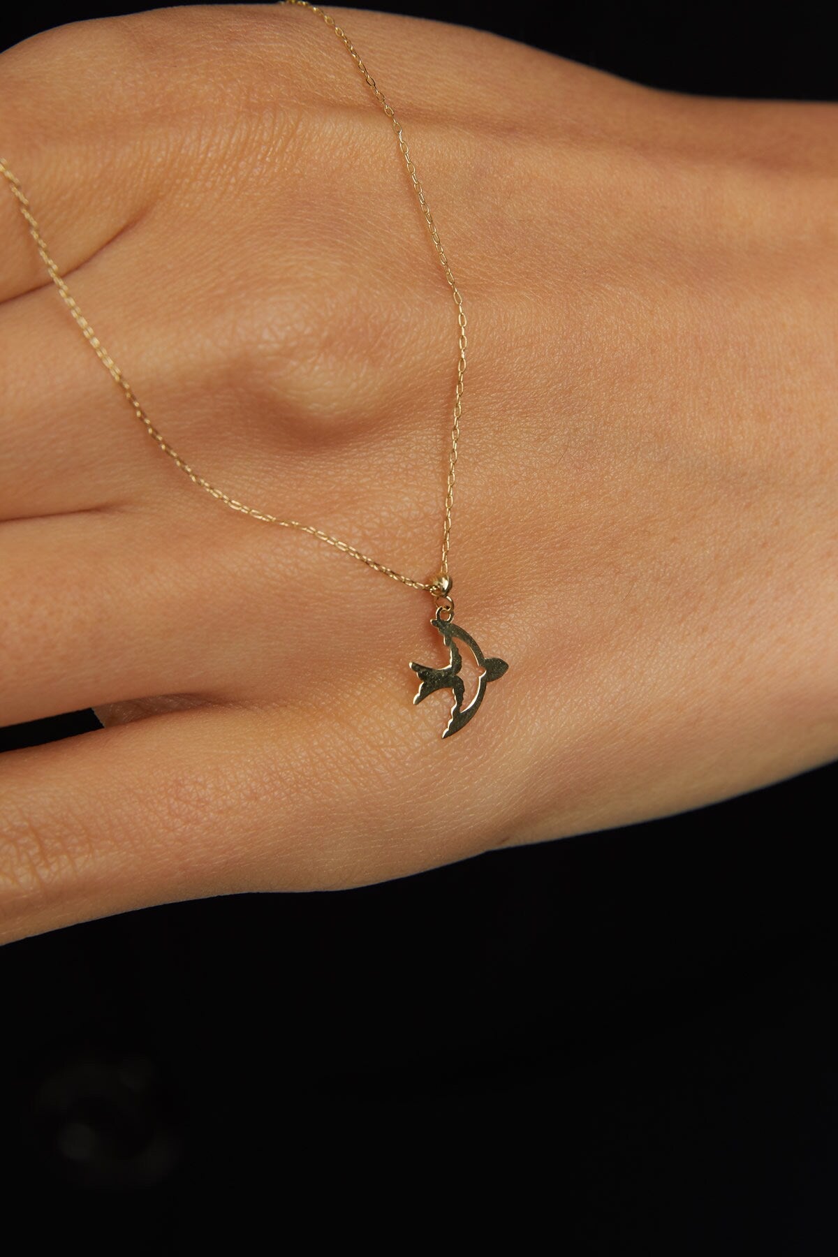 14K gold necklace with a flying bird pendant, graceful, and symbolic design.