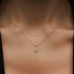 14K gold necklace with a flying bird pendant, graceful, and symbolic design.