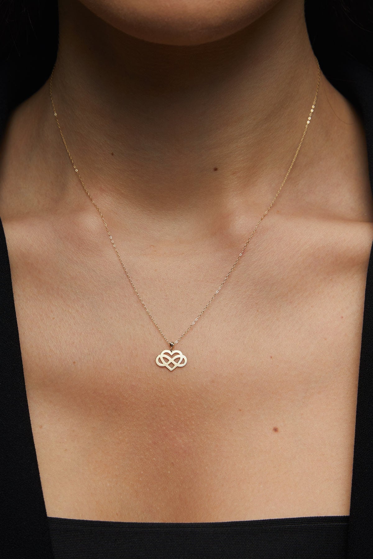 14K gold infinity heart necklace resting
