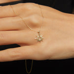 14K gold necklace featuring a radiant sunburst charm with pointed rays and a hollow center,