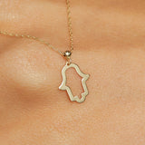 14K gold Hamsa hand necklace on emerald