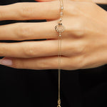 Elegant 14K gold bracelet with a cut-out seashell charm and faceted crystal beads, styled on rich emerald satin