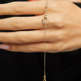 Elegant 14K gold bracelet with a cut-out seashell charm and faceted crystal beads, styled on rich emerald satin