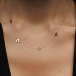 Minimalist 14K gold necklace with three evenly spaced clover charms,