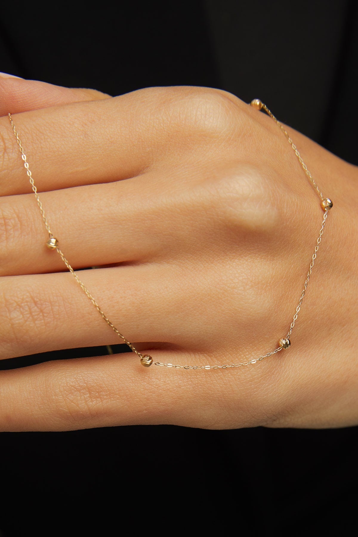 Minimalist 14K solid gold necklace with round beads spaced along a fine chain,