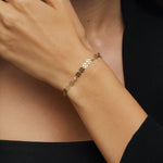 14K gold bracelet with circular disc charms and crystal beads displayed