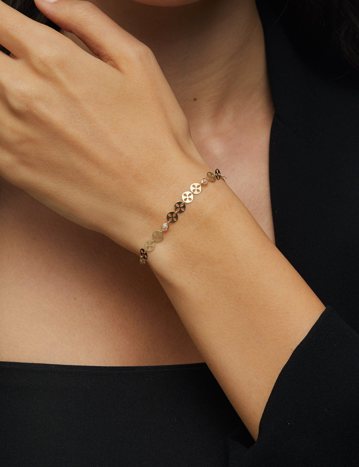 14K gold bracelet with circular disc charms and crystal beads displayed