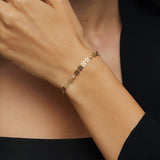 14K gold bracelet with circular disc charms and crystal beads displayed