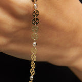 14K gold bracelet with circular disc charms and crystal beads displayed