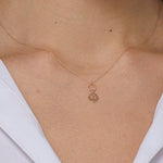 Elegant 14K gold necklace featuring a textured circle and a lotus flower pendant