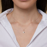 14K gold star charm necklace hanging from a textured gold circle pendant