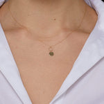 14K gold necklace with engraved initial M on round disc charm and twisted loop detail