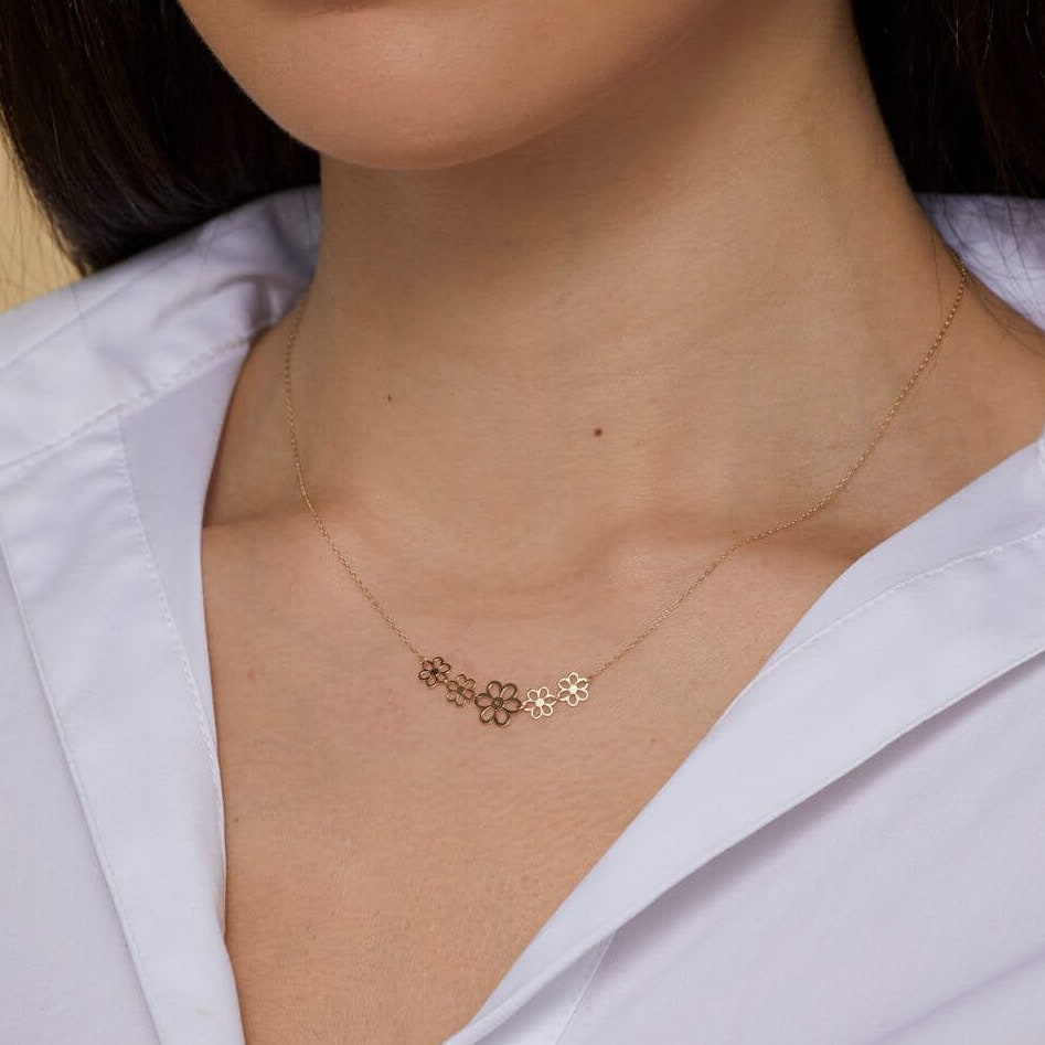 14K gold necklace with five small open flower charms displayed – elegant and minimalist.