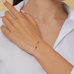 14K gold bracelet with two cross charms and a textured circular centerpiece