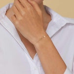 Minimalist 14K gold bracelet with two heart charms and a twisted circle link