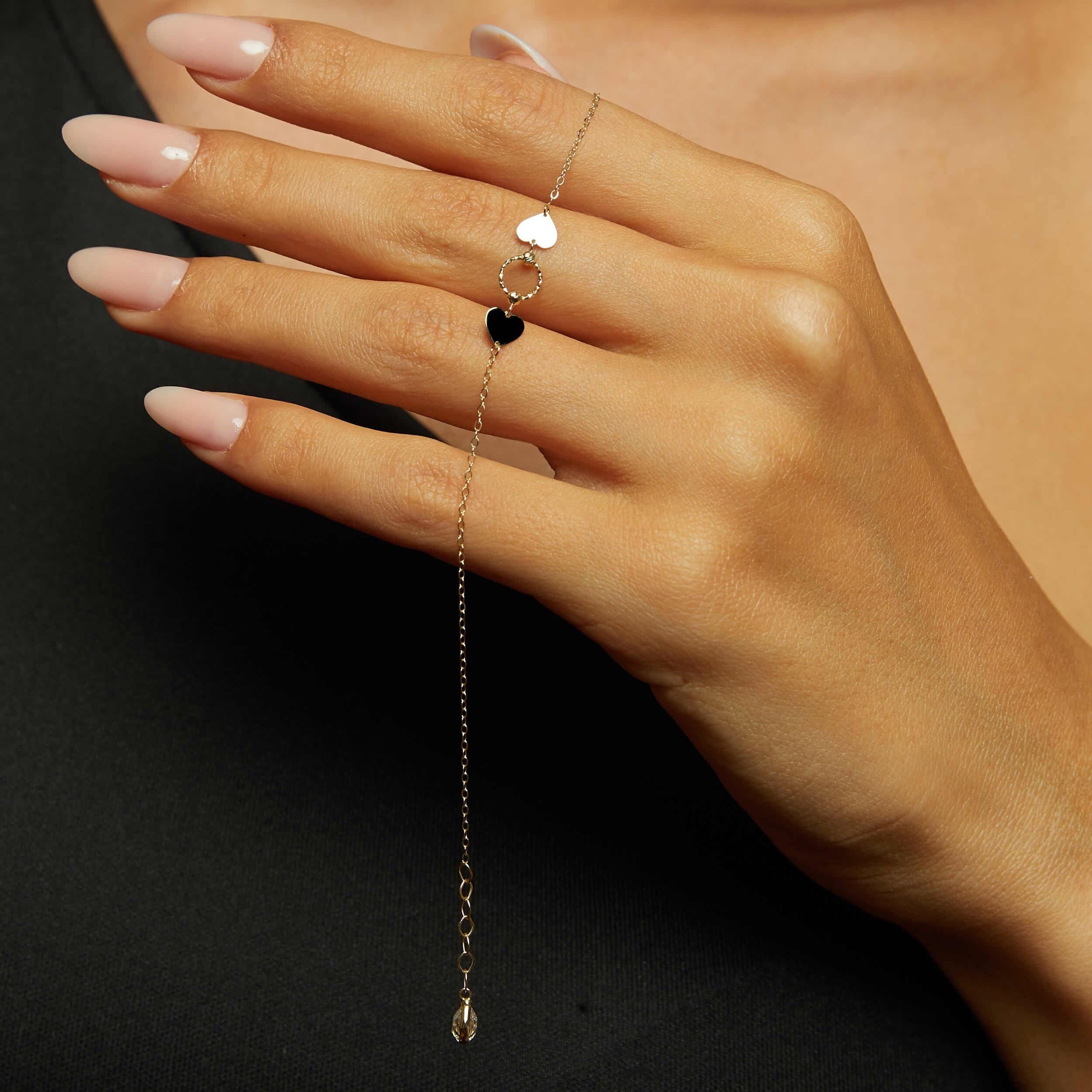 Minimalist 14K gold bracelet with two heart charms and a twisted circle link