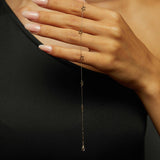 14K gold bracelet with delicate open star charms on green fabric