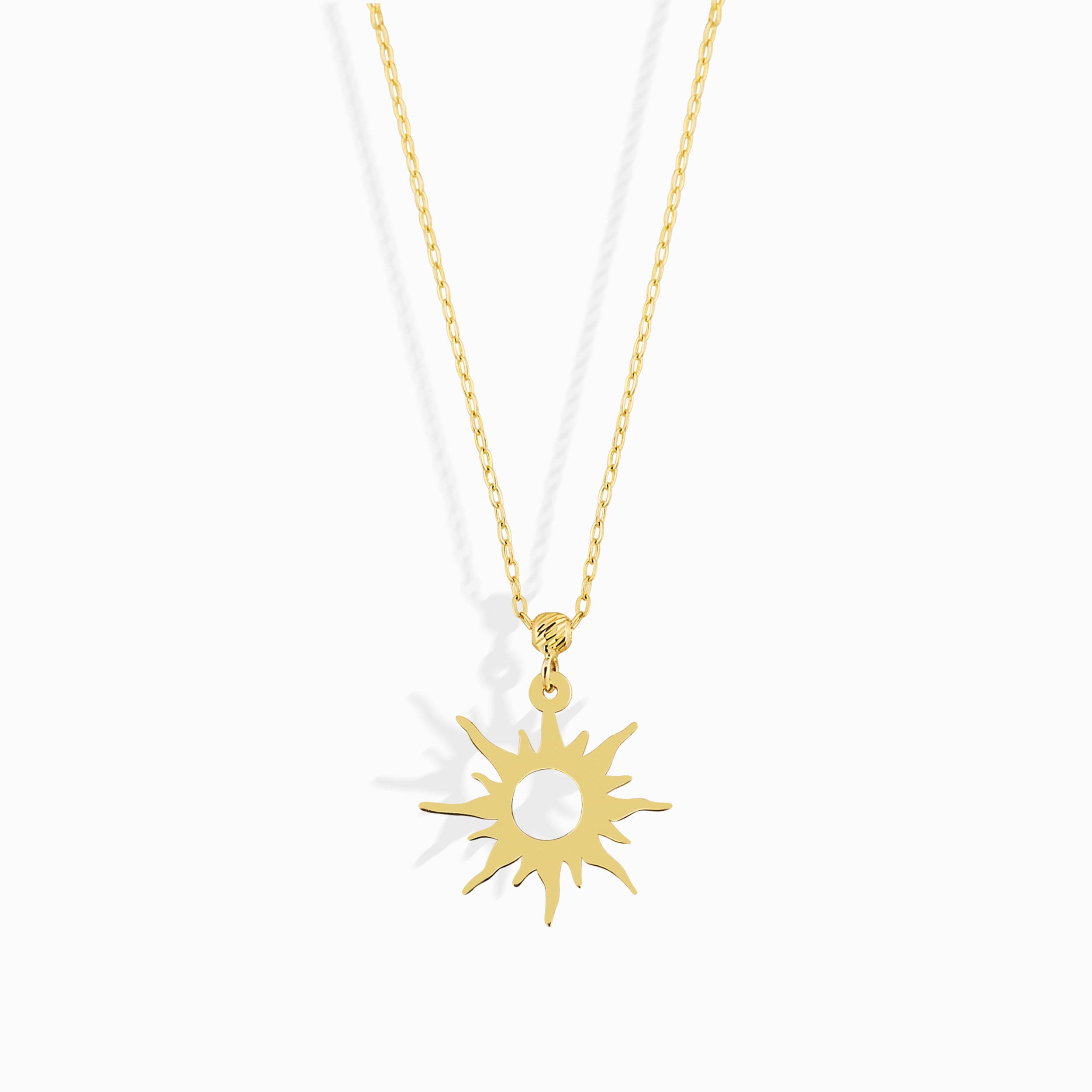 14K gold necklace featuring a radiant sunburst charm with pointed rays and a hollow center,