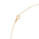 14K gold necklace with emerald teardrop pendant and butterfly charm worn on model’s neck