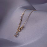 14K gold bracelet with a twisted circle centerpiece and two solid clover charms on a fine chain