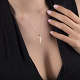 14K gold cross necklace with a 3D cutout design, placed on deep magenta satin fabric – minimal, spiritual, and contemporary.