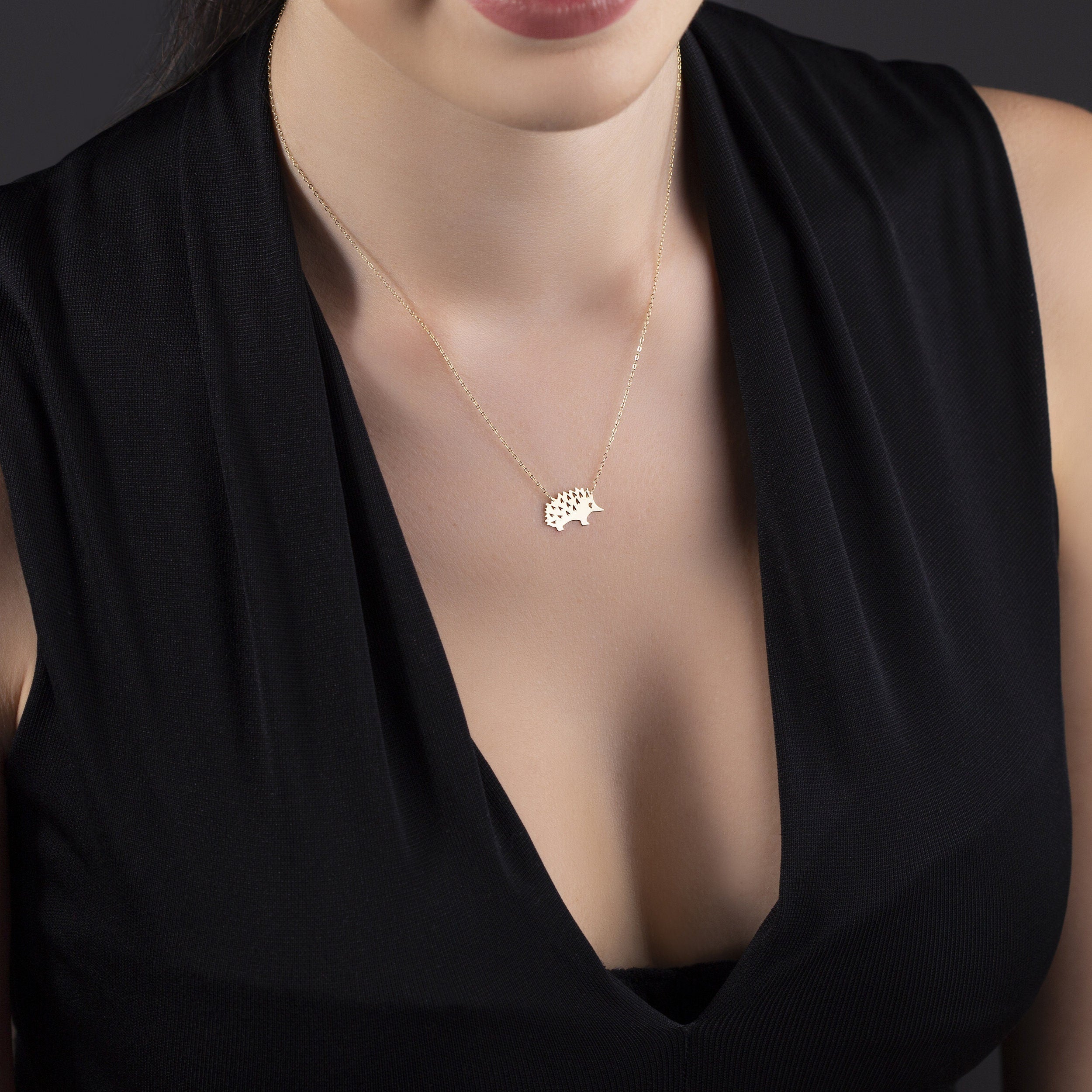 Close-up of a 14K gold hedgehog pendant necklace