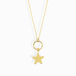 14K gold star charm necklace hanging from a textured gold circle pendant