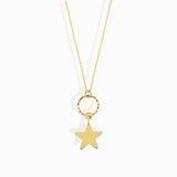 14K gold star charm necklace hanging from a textured gold circle pendant
