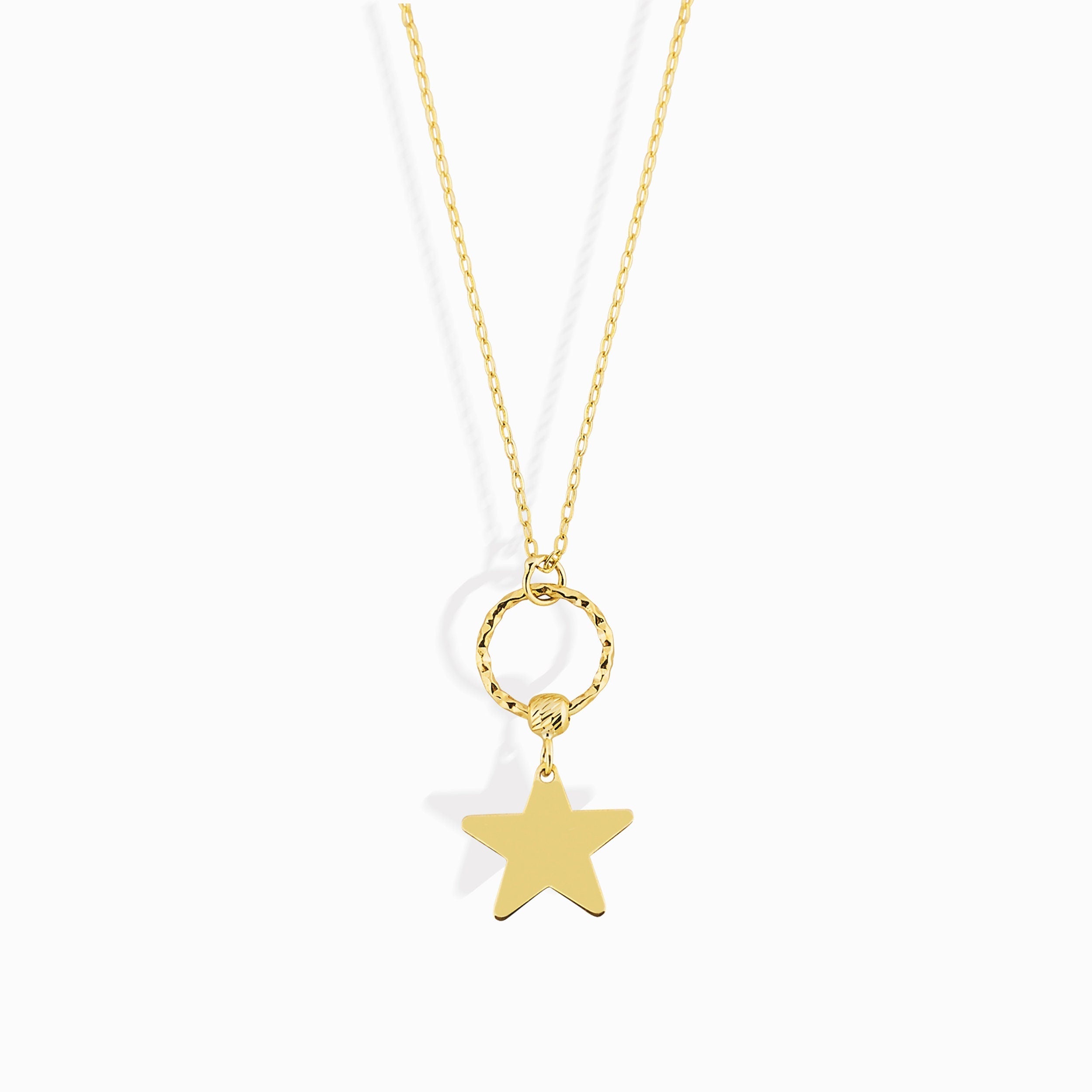 14K gold star charm necklace hanging from a textured gold circle pendant
