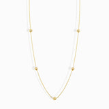 Minimalist 14K solid gold necklace with round beads spaced along a fine chain,