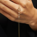 14K gold bracelet with lotus flower charm and faceted gemstone beads on emerald green satin background